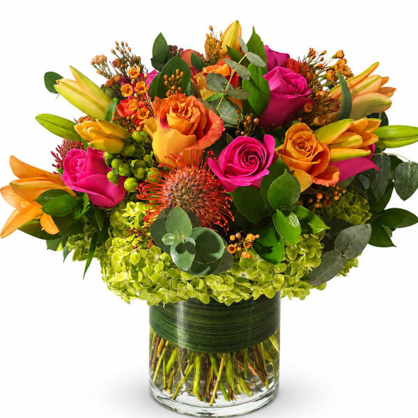 Bright mixed bouquet of roses and lilies in a glass vase