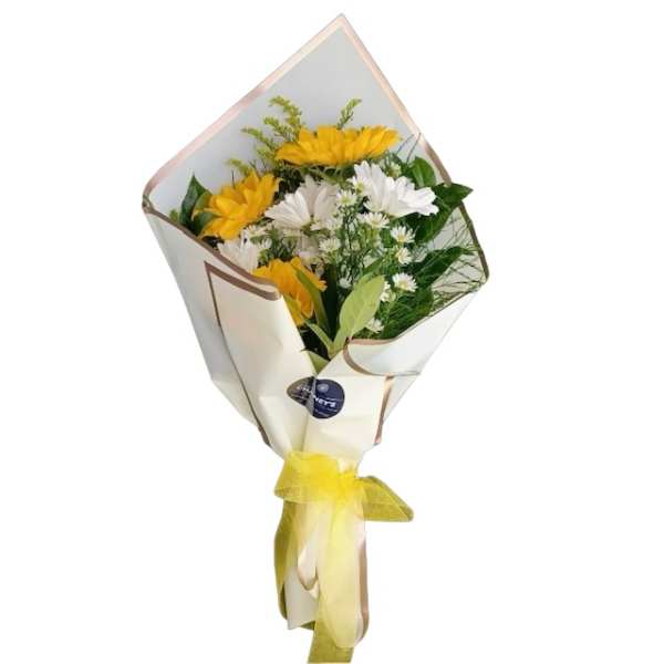 Bouquet of yellow and white daisies wrapped in cream paper with a yellow ribbon