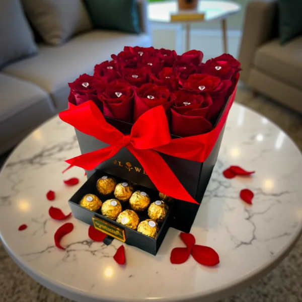 Box of red roses with a drawer of chocolates and a red ribbon
