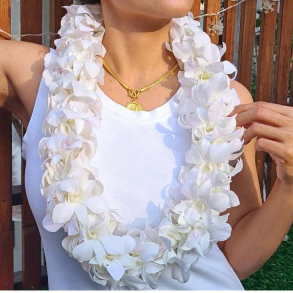 White orchid lei worn over a white tank top