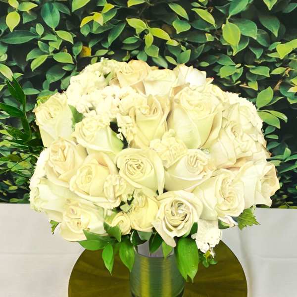 Cream rose bouquet in a metallic vase on a gold base