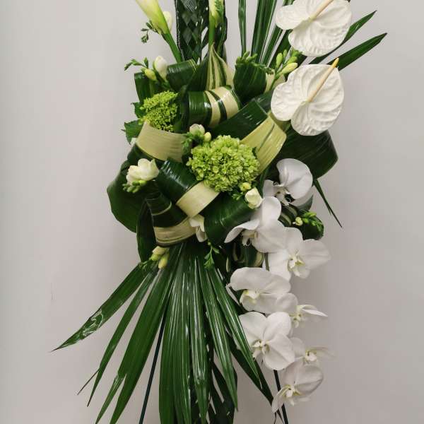 Tall white floral spray with calla lilies, orchids, and anthuriums
