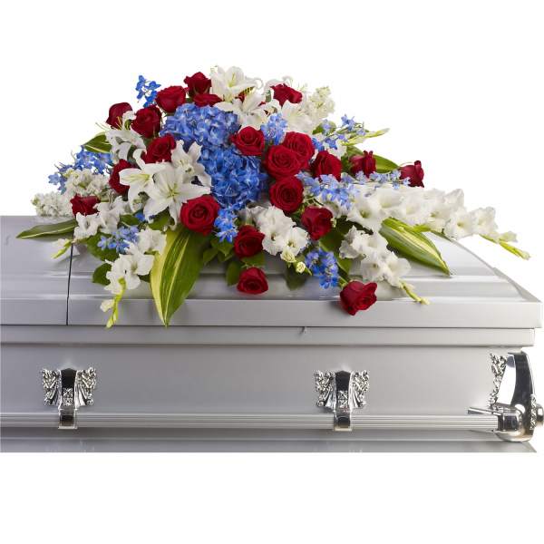 Red roses, white lilies, and blue flowers arranged on a silver casket