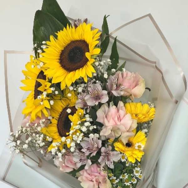 Bouquet of sunflowers and pink roses with small white filler flowers