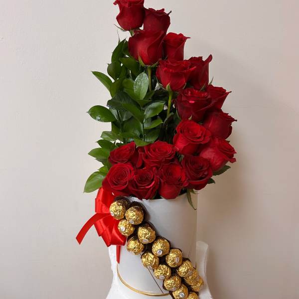 Red roses in a white hatbox with a red ribbon and Ferrero Rocher chocolates