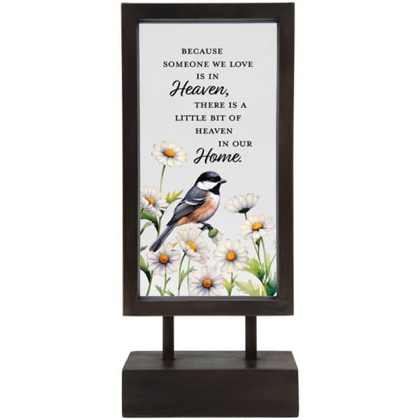 Framed memorial sign with daisies and a bird on a stand