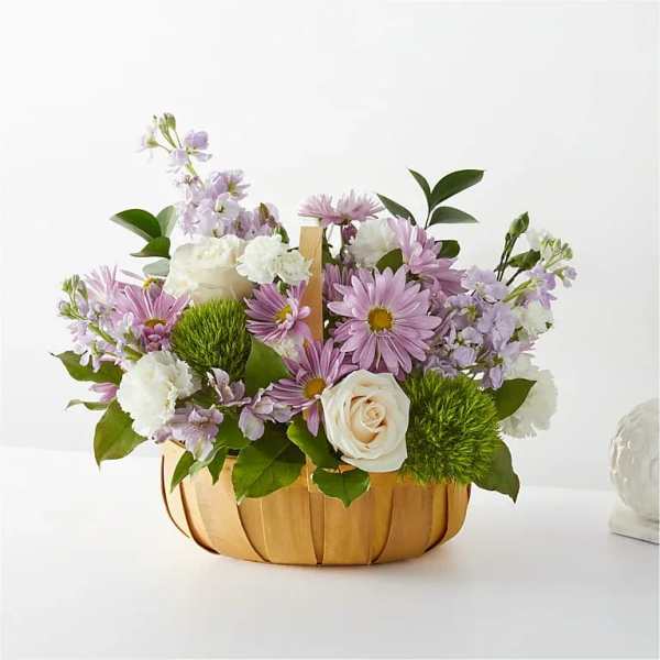 Basket arrangement of lavender daisies, white roses, and carnations
