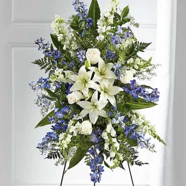 Tall standing floral spray with white lilies and blue flowers