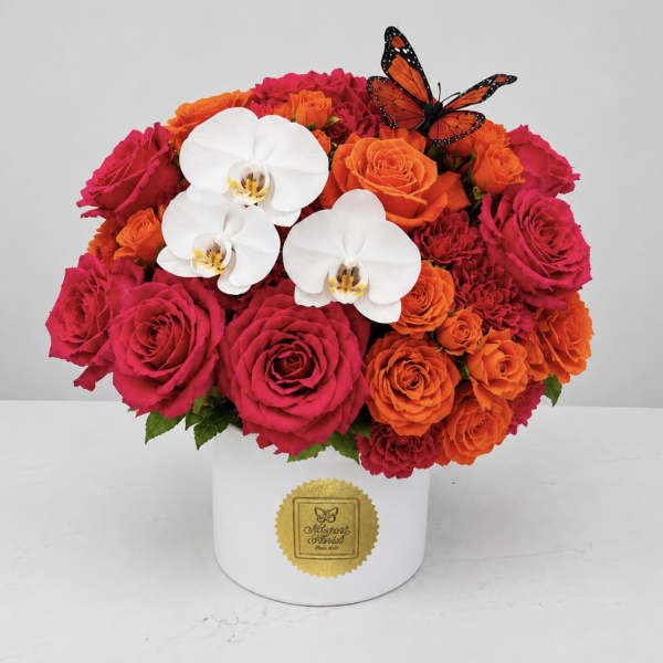Pink and orange roses with white orchids in a white hat box
