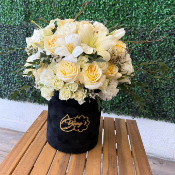 Cream and white flower arrangement in a black velvet box