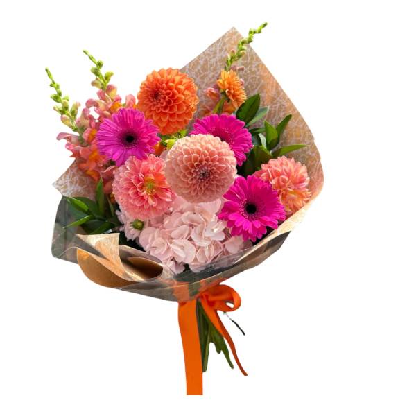 Bouquet of pink and orange flowers wrapped in patterned paper with an orange ribbon