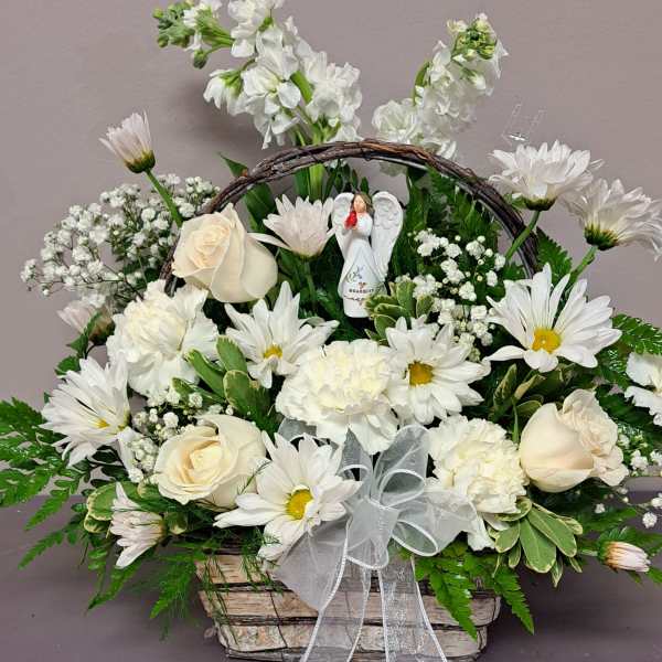 White flowers arranged in a basket with a ribbon and angel figurine