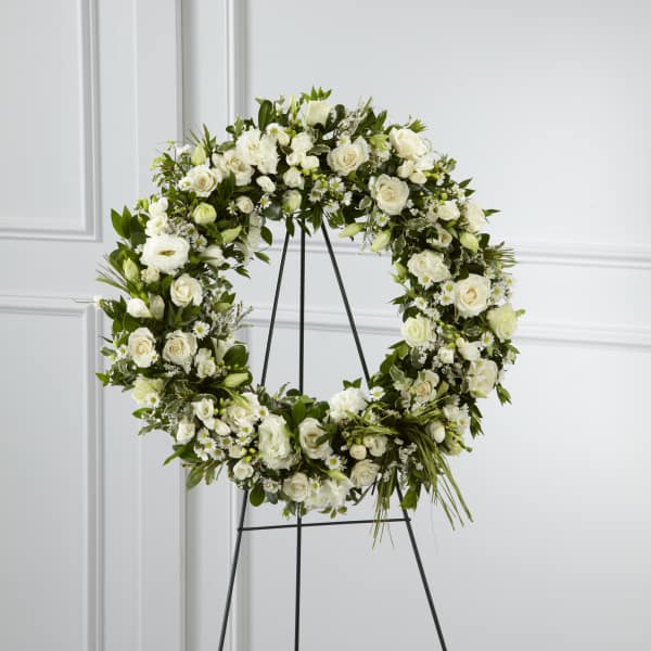 White floral wreath on a black stand