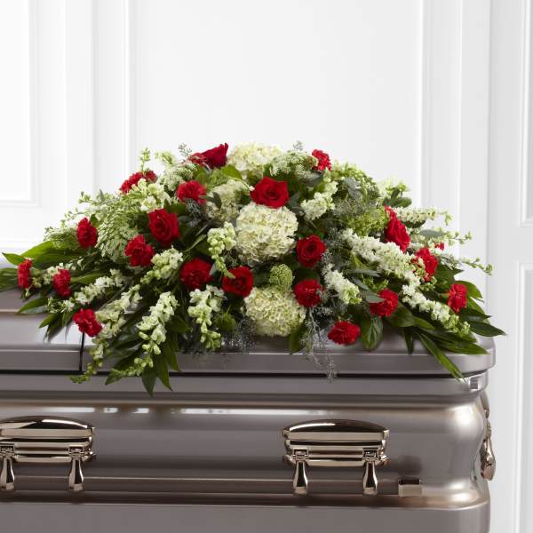 Red and white floral spray on a silver casket