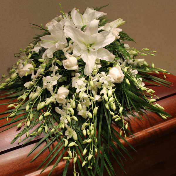 White floral spray on a wooden casket