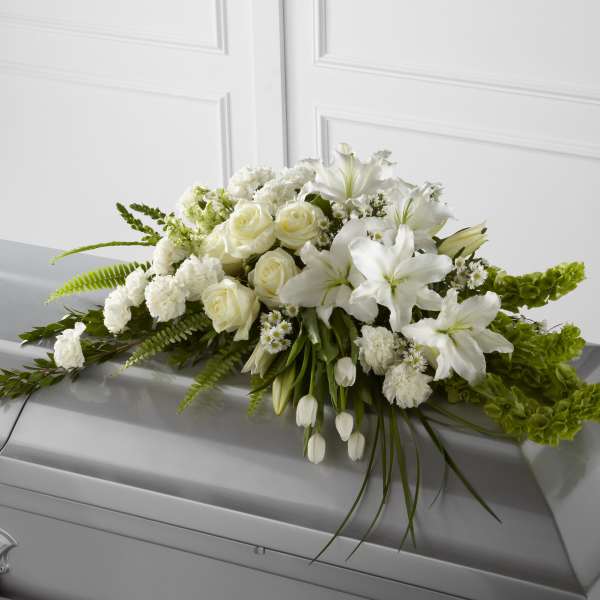 White floral casket spray with roses and lilies