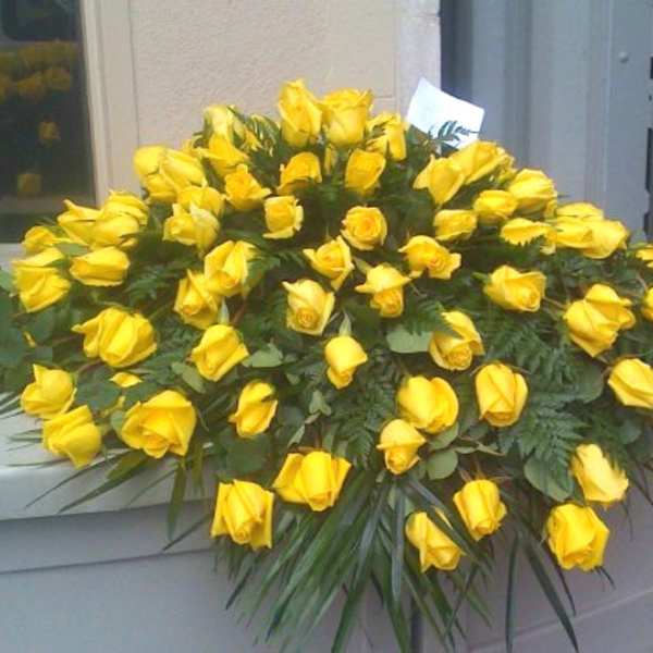 Large arrangement of yellow roses on a casket