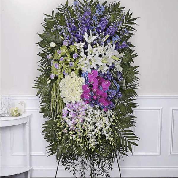 Standing floral spray with white lilies, orchids, and purple blooms