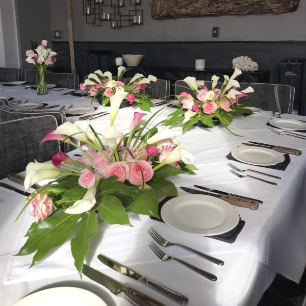 Pink and white floral centerpieces on a set dining table