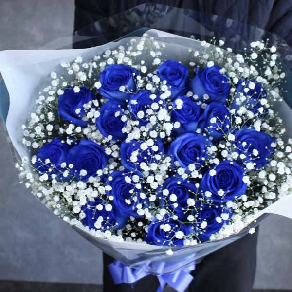 Bouquet of blue roses with white baby's breath in clear wrap