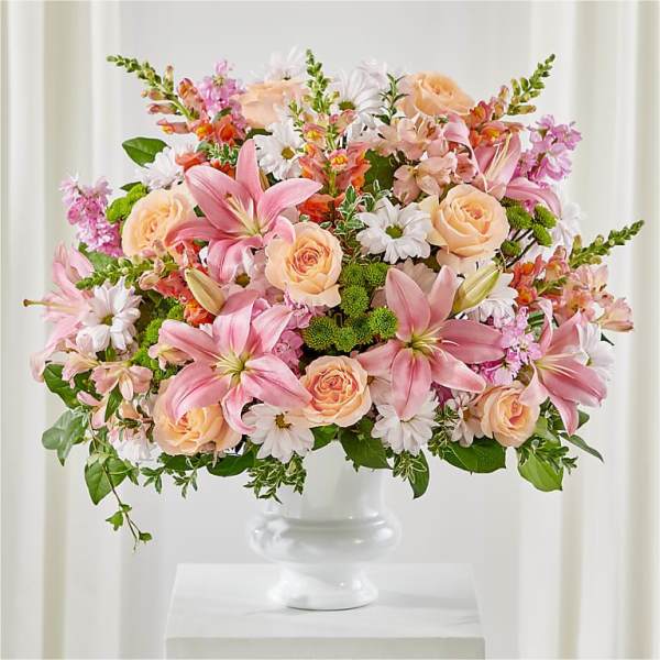 Pink lilies and peach roses in a white vase