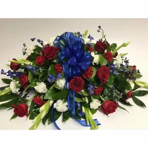 Red roses and white flowers arranged with a blue ribbon bow