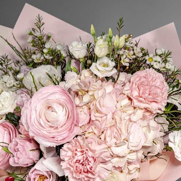 Bouquet of pale pink and white flowers wrapped in blush paper