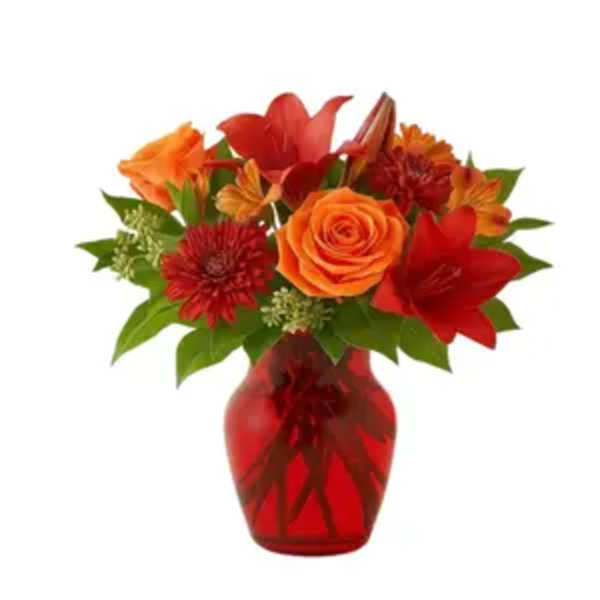 Orange and red mixed bouquet in a red glass vase