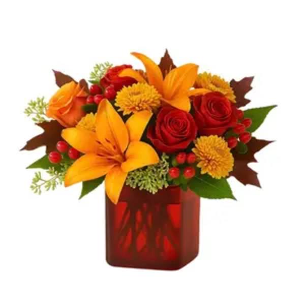 Orange lilies and red roses in a red glass vase