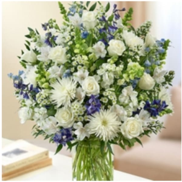 White and blue mixed flower bouquet in a glass vase