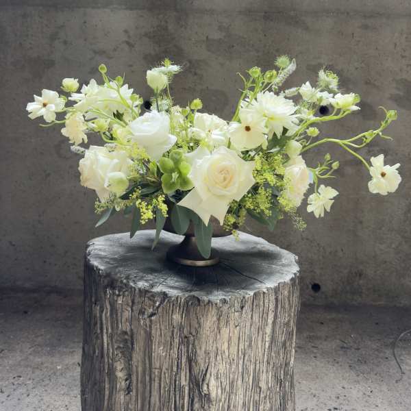 White floral arrangement in a low pedestal vase