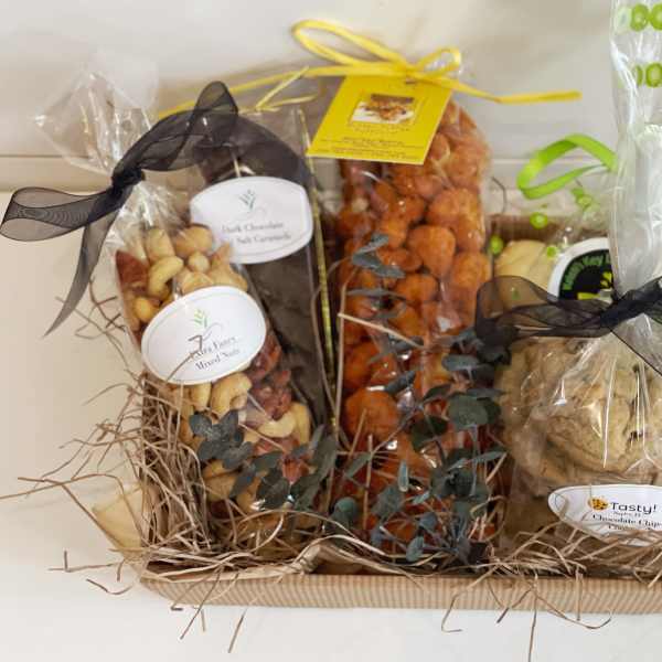 Gift basket with wrapped snacks and cookies tied with ribbons