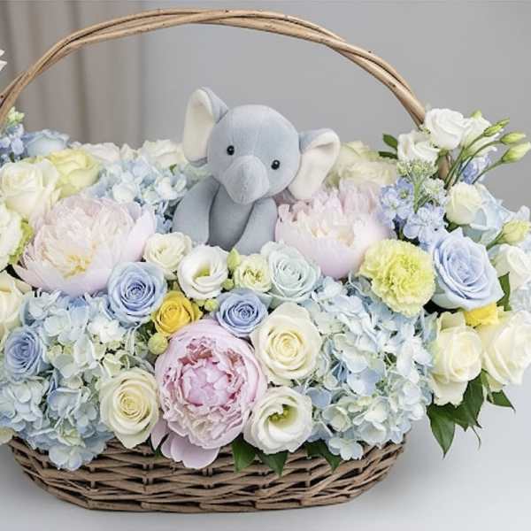 Basket of pastel flowers with a plush elephant in the center