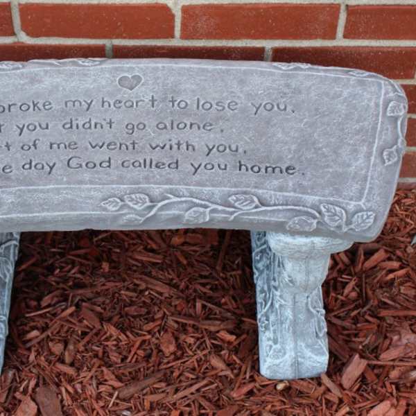 Stone memorial bench with an engraved sympathy message