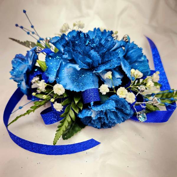 Blue carnation corsage with white baby's breath and ribbon