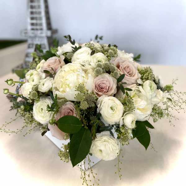 Blush and white bouquet of roses and ranunculus in a white box