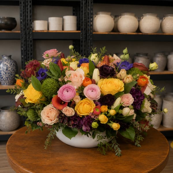 Colorful mixed flower arrangement in a white bowl vase