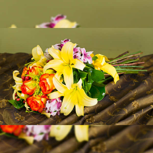 Bouquet of yellow lilies and orange roses with pink accents