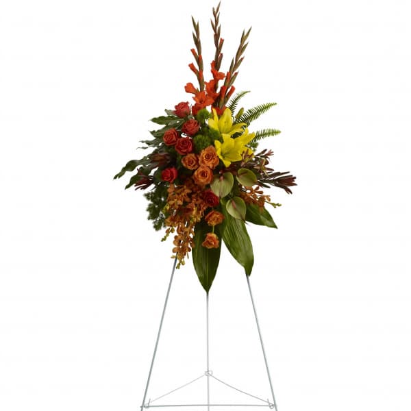 Tall floral spray with red and yellow flowers on a metal easel