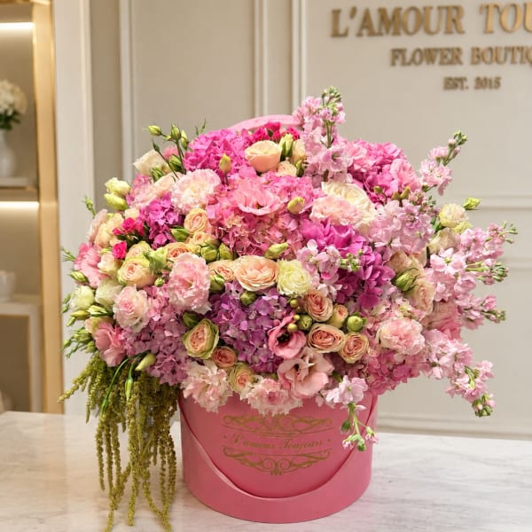 Large pink flower arrangement in a round pink box