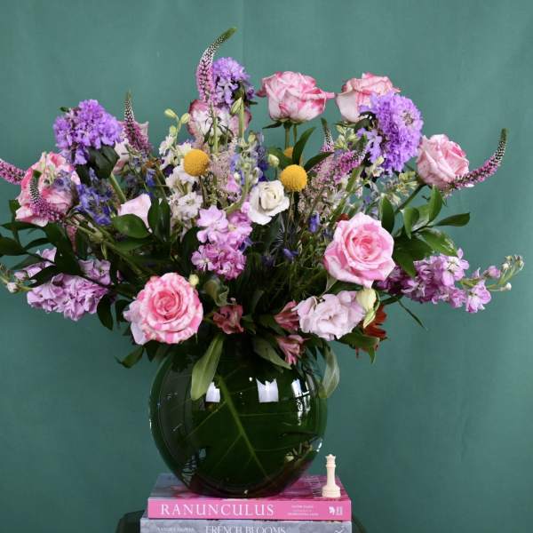 Pink and purple mixed bouquet in a dark glass vase