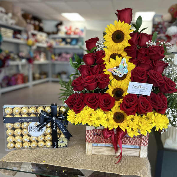 Red roses and yellow sunflowers arranged with a box of Ferrero Rocher chocolates
