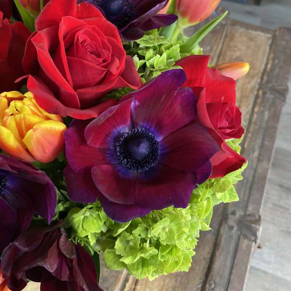 Bouquet of red roses, purple anemones, and orange tulips