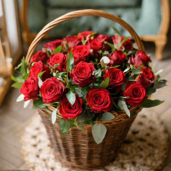 Basket of red roses with greenery