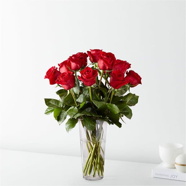 Red roses arranged in a clear glass vase