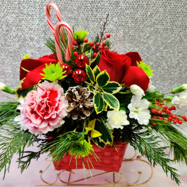 Holiday floral basket with red roses, pink carnation, and candy canes