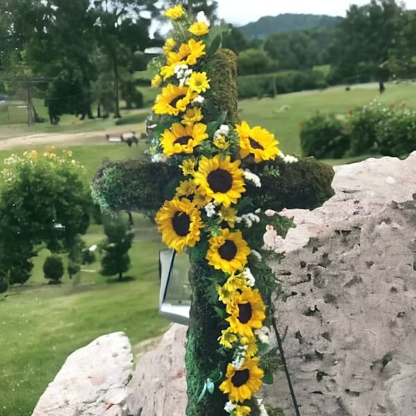 Sunflower garland draped over a large cross outdoors