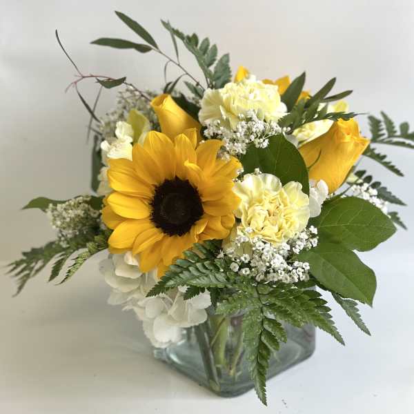 Sunflower and yellow rose bouquet in a square glass vase