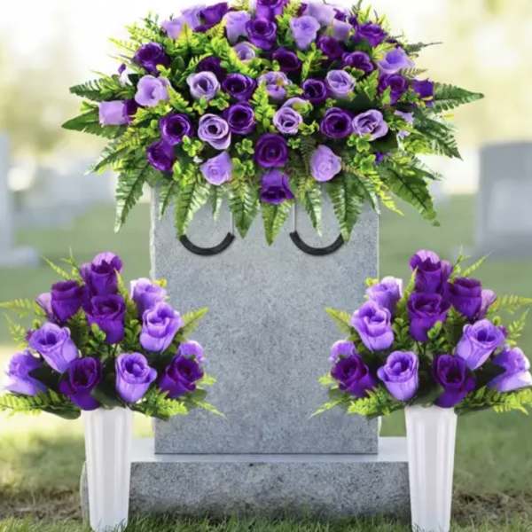 Purple rose funeral arrangement on a gravestone with two matching vase bouquets
