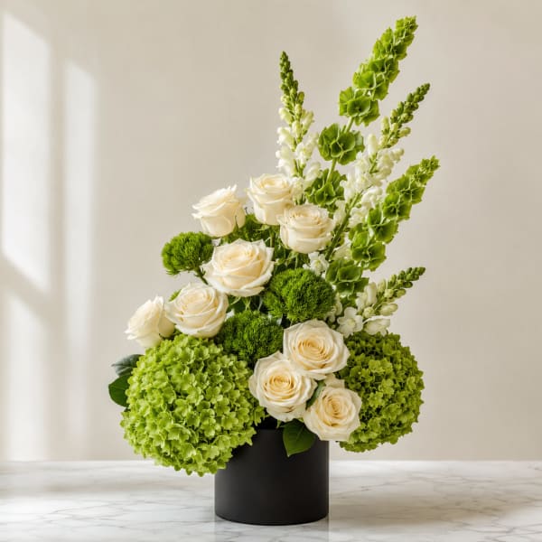White roses and green hydrangeas in a black vase